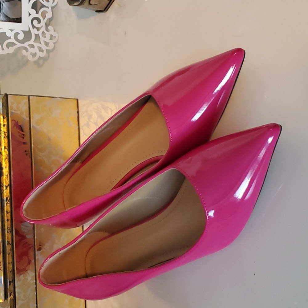 Pink patent leather kitten heel pumps.